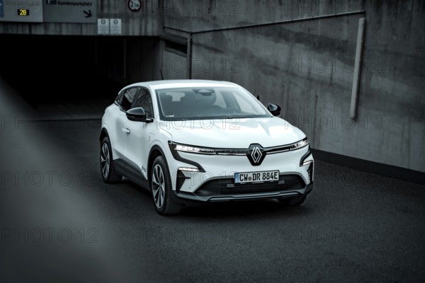 White modern SUV drives out of an underground car park on asphalt ground, Deer E-Carsharing,