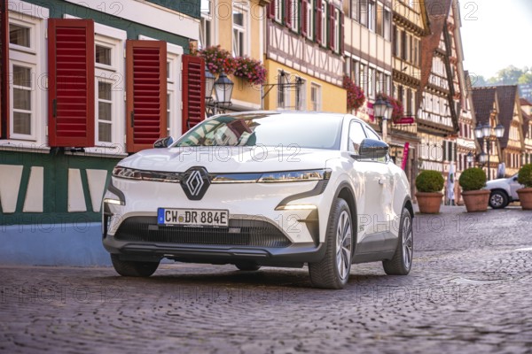 White car in picturesque old town with half-timbered houses and floral decorations, Deer