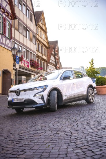 Renault Auto drives down the paved street of a historic town, Deer e-Carsharing, Renault Megane,