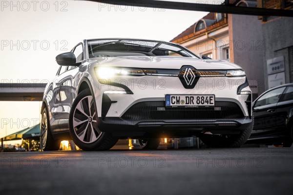 Low angle view of a car on an urban road in front of modern architecture, Deer E-Carsharing,