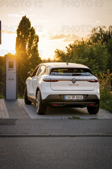 A car charges at a station, illuminated by the warm shade of sunset, Deer E-Carsharing, Renault