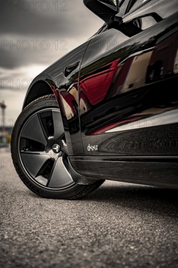 Close-up of a car tire on asphalt, reflective surface, Deer e-car sharing, Tesla Model 3, Calw,