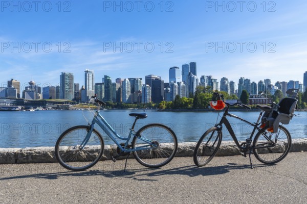 Two bicycles parked along the stanley park seawall overlook vancouver's stunning cityscape,