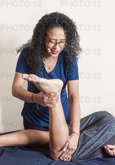 Physiotherapist with patient performing knee flexion, Physiotherapist performing knee flexion