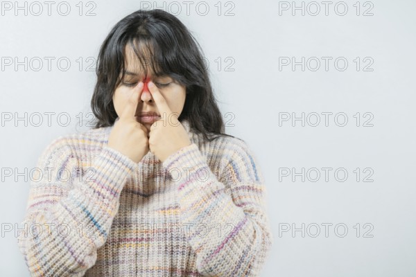 Asian woman with rhinitis touching nose. Close up of young woman with sinus pain touching nose