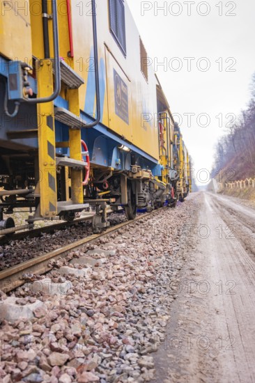 Close-up of gravel tracks with a yellow tool in the background, stuffing machine on Hermann, Hesse,