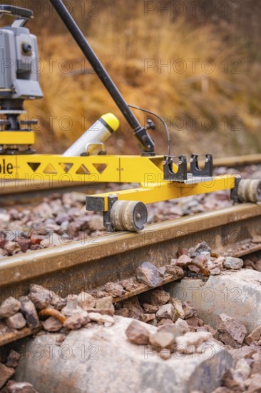 Close-up of a yellow device on railroad tracks in an autumn landscape, stuffing machine on Hermann,