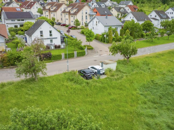 Aerial view of a suburb with houses and a street surrounded by greenery, Deer E-Carsharing, Calw,