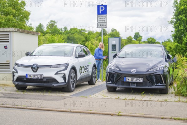 Electric cars park with a view of charging station, surrounded by green vegetation, Deer