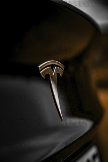 Close-up of Tesla logo on black car with dark background, Deer E- car sharing, Tesla Model 3, Calw,