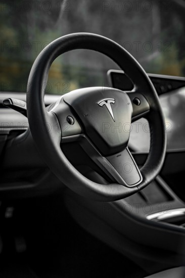 Close-up of a black steering wheel in a modern vehicle interior, Deer e-Carsharing, Tesla Model 3,