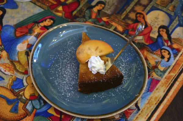 Piece of cake decorated with a mango slice served in a Persian café, Fürth, Middle Franconia,