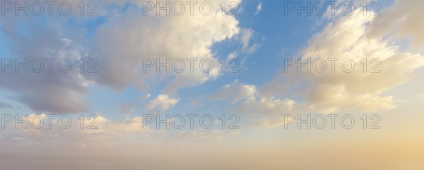 Colorful sunset sky showcases vibrant hues and fluffy clouds as day transitions into night,