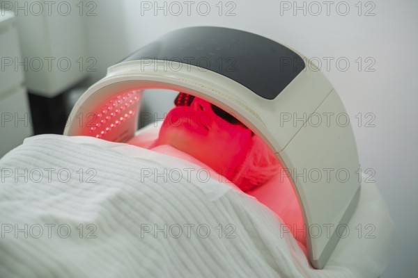 Client undergoes facial cleansing with LED light therapy to target acne while protected by goggles