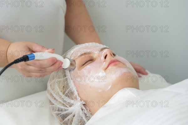 Client relaxes as a specialist applies a metallic applicator during RF lifting, promoting skin
