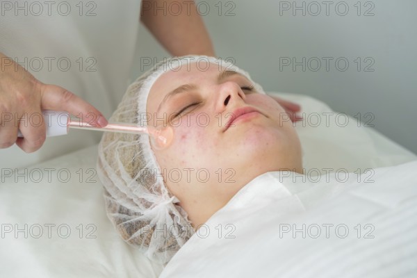 Client receives Darsonvalization treatment with a glass electrode to enhance skin healing and
