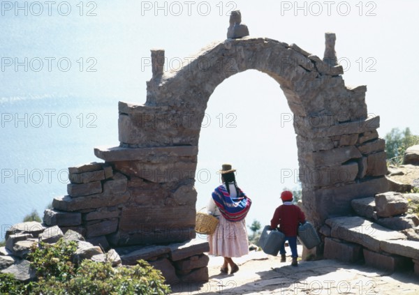 Archway, traditionally dressed woman, child on Isla Taquile in Lake Titicaca, Andean highlands,