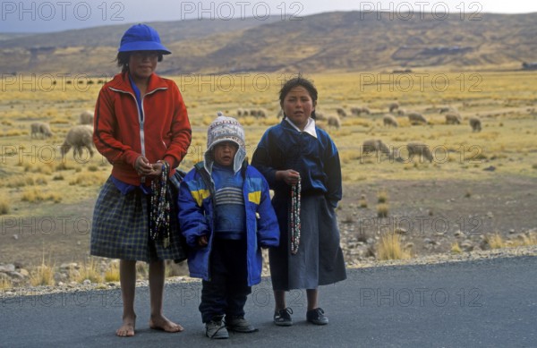 Children sell cheap jewelry on the roadside near Puno, Andean Highlands, Peru, South America,