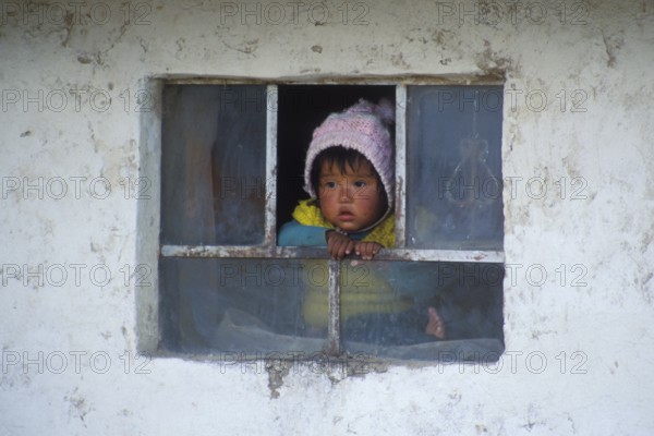 Little child looking out of a window near Cusco, Andean Highlands, Peru, South America, September