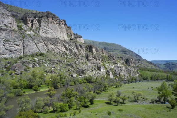 A river flows through a green valley with rocky slopes and trees, Kura River, landscape near