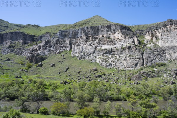 Green hills and imposing cliffs with picturesque skies. Pristine natural scenery, cave town, cave