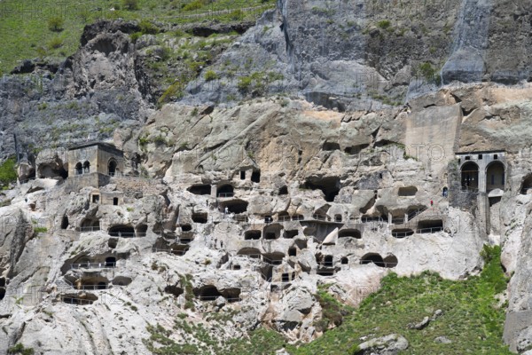 A rocky wall with numerous cave openings carved into the stone, cave town, cave monastery, Vardzia,