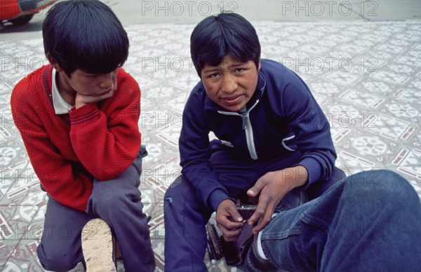 Teenager, young shoe cleaner at work, Puno on Lake Titicaca, Andean highlands, Peru, South America,