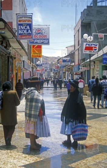Advertising signs, people, woman, pedestrian zone in Puno, Andean highlands, Peru, South America,