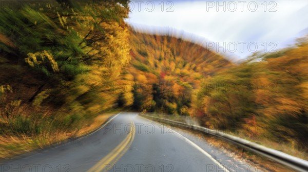 Curvy country road, downhill, autumn leaves, Indian summer, traveling, symbolic photo, zoom effect,