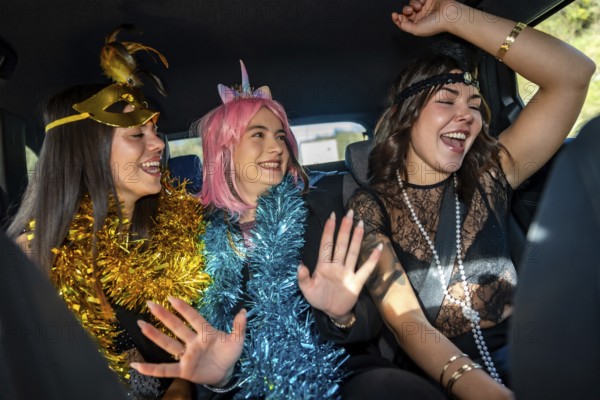 Young women friends celebrating a joyful costume party inside a car, expressing happiness and fun
