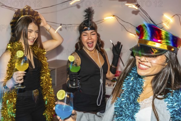 Young women friends celebrating new year's eve or a costume party indoors, laughing and dancing