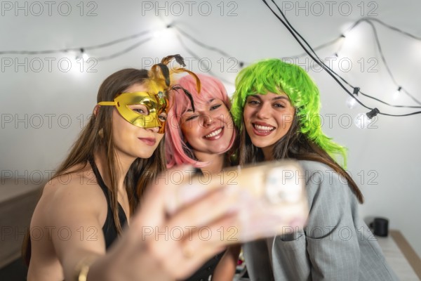 Group of happy young women celebrating new year's eve or a costume party indoors, smiling and