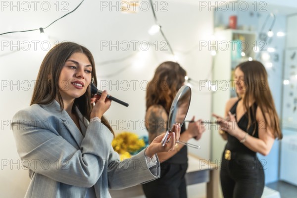 Friends women applying makeup and styling hair, preparing for a festive new year's eve party or