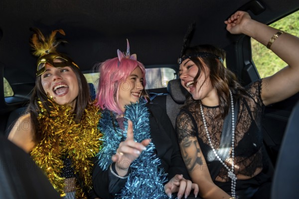 Young happy women dressed in costumes and festive garlands celebrating, laughing, and having fun