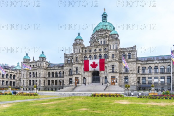 British columbia parliament buildings with large canadian flag hanging from the front during a
