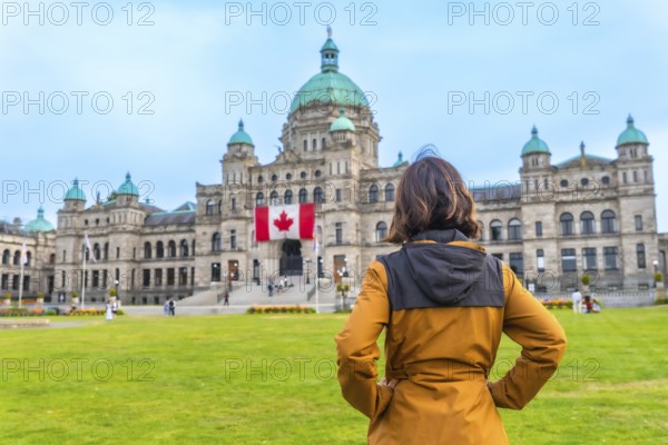 Tourist standing in front of the impressive parliament buildings, proudly displaying the canadian