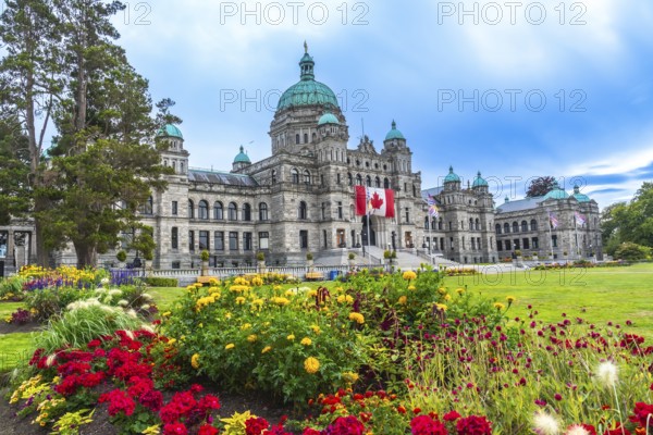 Canadian flag waving in front of parliament buildings in victoria, british columbia, canada during
