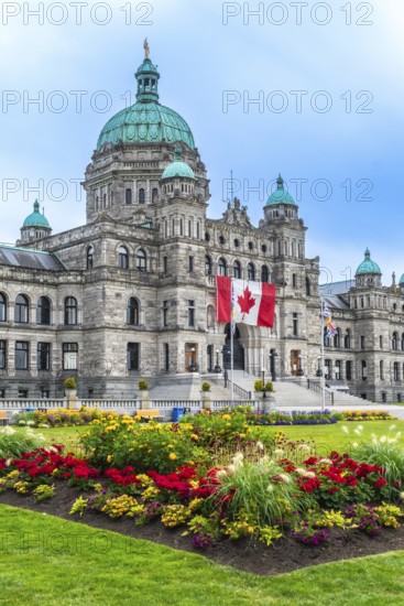 Canadian flag waving proudly in front of the british columbia parliament buildings in victoria,