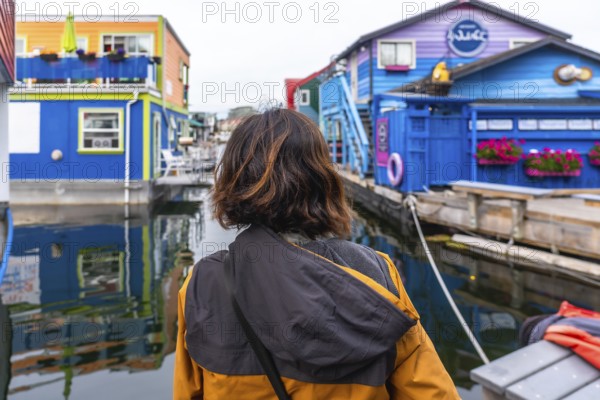 Tourist admiring the colorful floating houses of fisherman's wharf park, a popular tourist