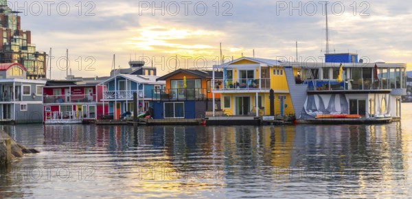 Colorful floating homes reflecting in the calm water at fisherman's wharf park in victoria, british