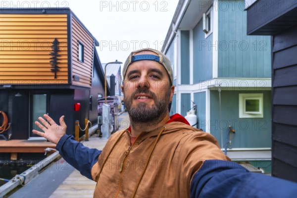 Tourist taking a selfie and showing with his hand floating houses in fishermans wharf park,