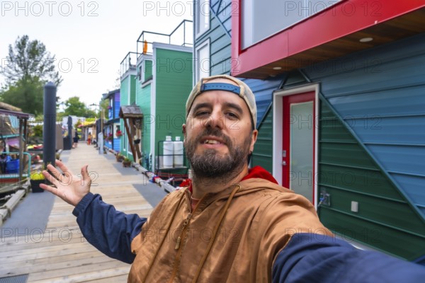 Tourist taking a selfie and showing colorful floating homes in fisherman's wharf park, a popular
