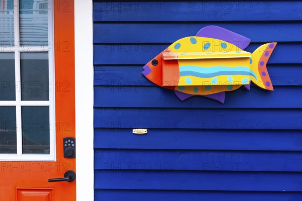 Whimsical fish shaped mailbox adds a touch of charm to a brightly colored blue house in victoria,