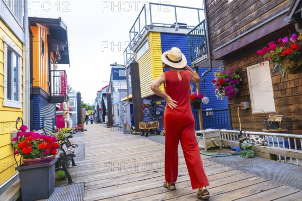 Tourist wearing a straw hat and a red jumpsuit walking in fisherman's wharf park, a colorful
