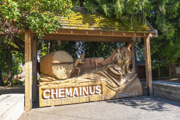 Wooden sculpture depicting loggers working with logs and tools, commemorating the rich history of