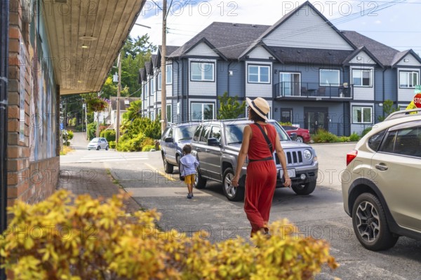 Mother and son enjoying a leisurely stroll along a charming sidewalk in chemainus, surrounded by