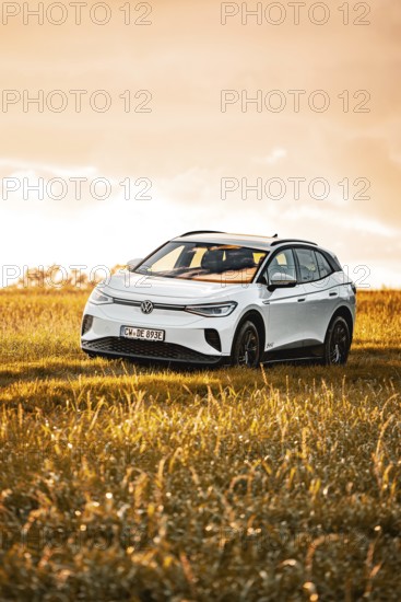 A white Volkswagen SUV on a sunlit meadow, VW ID4 electric car, Deer Carsharing, Calw, Germany