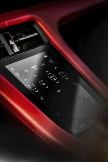 Close-up of car interior with red touchscreen control panel and modern displays, Porsche Taycan,