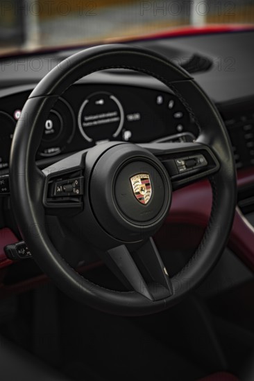 Black steering wheel in the luxurious interior of a Porsche, Porsche Taycan, Deer Carsharing. Calw,