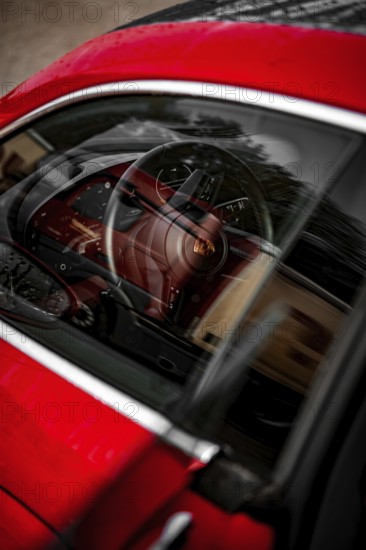 Red car interior with steering pane and reflections in the window, Porsche Taycan, Deer car sharing